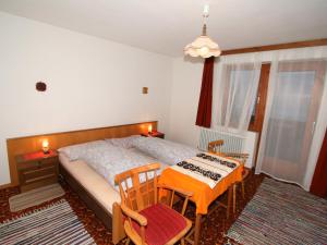 キルヒベルク・イン・チロルにあるApartment Straif by Interhomeのベッドルーム1室(ベッド1台、テーブル、椅子付)