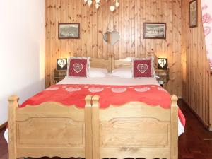 ein Schlafzimmer mit einem Holzbett mit einer roten Decke in der Unterkunft Apartment Coup d'Coeur by Interhome in Valtournenche + 23 Fotos