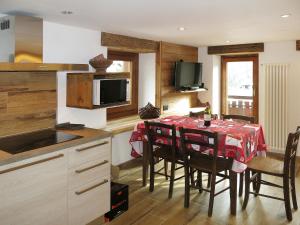 cocina con mesa con sillas y TV en Apartment Plen Solei by Interhome, en Valtournenche