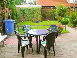 a table and chairs sitting around a patio table and chairs at Apartment Schonerweg by Interhome in Norddeich