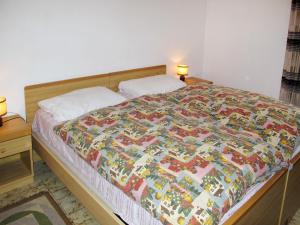 ein Bett mit einer bunten Decke in einem Schlafzimmer in der Unterkunft Apartment Martinelli by Interhome in Calceranica al Lago