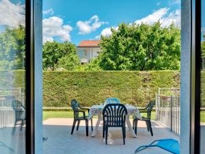 een tafel en stoelen op een patio met uitzicht op een tuin bij Apartment Agostini-2 by Interhome in Caldonazzo