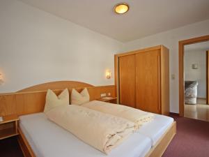 una camera con letto bianco e testiera in legno di Apartment Handle-2 by Interhome a Ried im Oberinntal