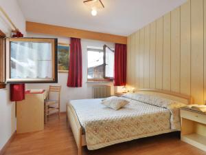 1 dormitorio con cama, mesa y ventana en Apartment Lazzer-1 by Interhome, en Campitello
