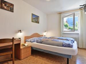 a bedroom with a bed and a desk and a window at Apartment Cecilia-2 by Interhome in Campitello +17 photos