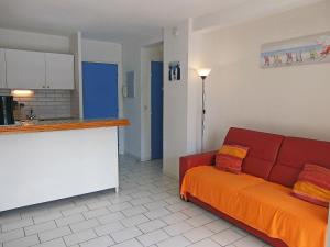 Plage dʼArgelèsにあるApartment Santa Maria by Interhomeのリビングルーム(赤いソファ付)、キッチン