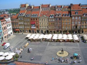 ワルシャワにあるApartment Rynek Starego Miasta by Interhomeの市街地の傘とテーブルを持つ建物群