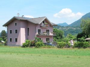 een roze huis bovenop een veld bij Apartment Deval-1 by Interhome in Calceranica al Lago