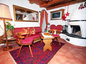 een woonkamer met een rode bank en een open haard bij Apartment Lener-2 by Interhome in Matrei am Brenner