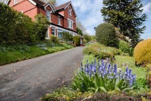 a house with purple flowers on the side of a road at Mynd House in Church Stretton