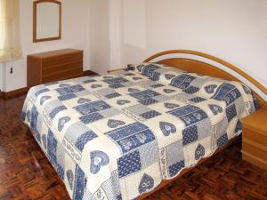 a bedroom with a bed with a blue and white quilt at Holiday Home Casa al Mulino by Interhome in Calceranica al Lago