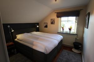 a bedroom with a large bed with a window at At Home Bed & Breakfast in Gothenburg