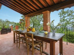Une table et des chaises en bois sont disponibles sur la terrasse. dans l'établissement Holiday Home Villa I Cipressi by Interhome, à Nievole