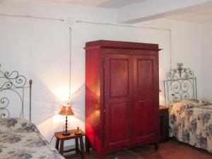 un armario rojo en un dormitorio con 2 camas en Holiday Home Borgo La Cella-1 by Interhome, en Pian di Scò