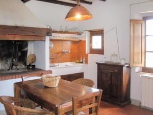 cocina con mesa de madera y chimenea en Holiday Home Borgo La Cella-1 by Interhome, en Pian di Scò