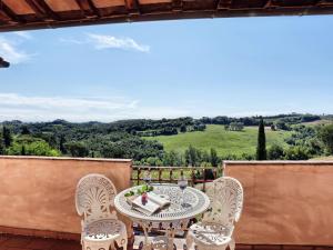 una mesa y sillas en un balcón con vistas en Holiday Home Pillo di Sopra by Interhome, en Querce