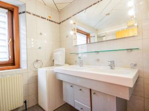 La salle de bains est pourvue d'un lavabo et d'un miroir. dans l'établissement Apartment Höpperger by Interhome, à Flaurling