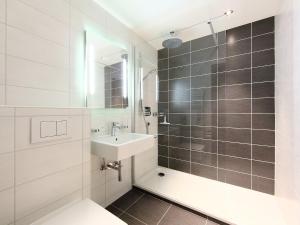 ein weißes Bad mit einem Waschbecken und einer Dusche in der Unterkunft Apartment Opale 4 by Interhome in Villars-sur-Ollon