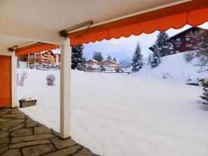 a snow covered patio with a view of a snow covered yard at Apartment Opale 4 by Interhome in Villars-sur-Ollon