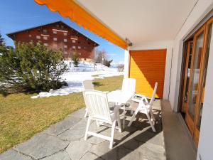 einen Tisch und Stühle auf einer Terrasse in der Unterkunft Apartment Opale 4 by Interhome in Villars-sur-Ollon