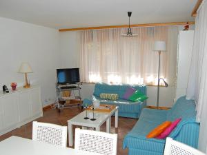 a living room with two blue couches and a tv at Apartment Ambassador I Apt 7 by Interhome in Nendaz