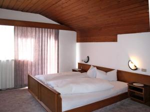 um quarto com uma cama grande e um tecto em madeira em Apartment Haupthaus Schönblick - SVH117 by Interhome em San Valentino alla Muta
