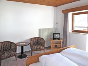 um quarto com uma cama, 2 cadeiras e uma mesa em Apartment Haupthaus Schönblick - SVH117 by Interhome em San Valentino alla Muta