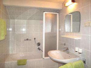 uma casa de banho com um lavatório, uma banheira e um espelho. em Apartment Haupthaus Schönblick - SVH117 by Interhome em San Valentino alla Muta