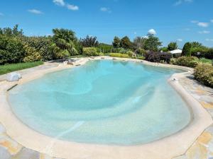 a large swimming pool with blue water at Holiday Home Azienda Agricola Forzello-1 by Interhome in San Basilio