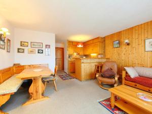 een woonkamer met een tafel en een keuken bij Apartment Sapin Bleu 6 by Interhome in Villars-sur-Ollon