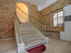 - un escalier dans un ancien bâtiment en briques avec une fenêtre dans l'établissement Apartment Barbaria de le Tole by Interhome, à Venise
