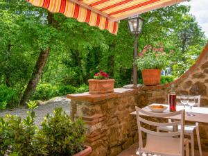 patio con tavolo e sedie sotto ombrellone di Holiday Home La Fornace-1 by Interhome a Il Molinaccio