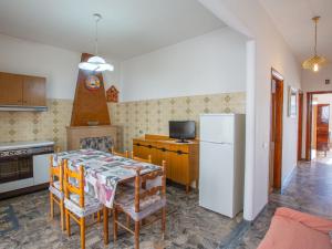 Una cocina con una mesa y un refrigerador blanco. en Apartment Villa Teresa by Interhome, en Peschici