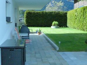 un patio con sillas y césped en Apartment Chalet am Reeti by Interhome, en Grindelwald