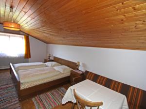 a bedroom with two beds and a wooden ceiling at Apartment Jägerhof-2 by Interhome in Hochpillberg