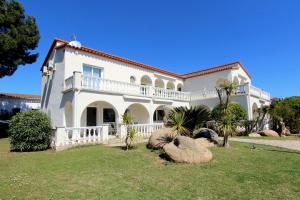 ein großes weißes Haus mit Palmen im Hof in der Unterkunft LEON INMO Apartment Celine - 10413 in Empuriabrava