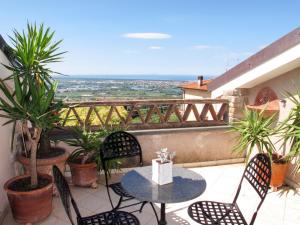 eine Terrasse mit einem Tisch und Stühlen auf dem Balkon in der Unterkunft Villa Capo Corso by Interhome in Corsanico-Bargecchia