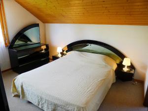 um quarto com uma cama e uma televisão de ecrã plano em Apartment Grenat 35 by Interhome em Villars-sur-Ollon
