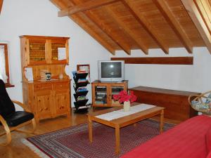 Apartment Casa Strecce 1 by Interhome في Crana: غرفة معيشة مع تلفزيون وطاولة