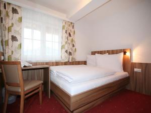 a bedroom with a bed and a desk and a window at Apartment Pfeifer-2 by Interhome in Pians +11 photos