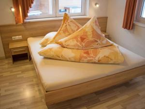 łóżko z poduszkami w pokoju w obiekcie Apartment Bella Monte-2 by Interhome w mieście Pettneu am Arlberg