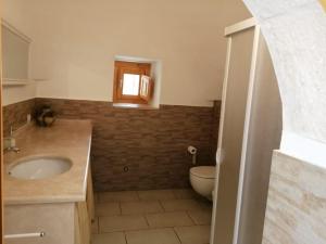 La salle de bains est pourvue d'un lavabo et de toilettes. dans l'établissement Tenuta Tinelli Sonia, à Noci