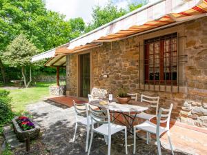 une table et des chaises devant une maison en pierre dans l'établissement Holiday Home La Fornace-2 by Interhome, à Il Molinaccio