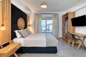 sypialnia z łóżkiem, biurkiem i telewizorem w obiekcie White Rock Villas Nikiana w mieście Nikiana +37 zdjęć
