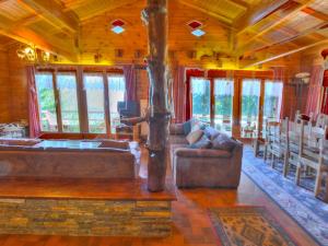 a living room with couches and a table and windows at Chalet Clarine by Interhome in Anzère