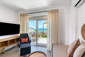 salon z telewizorem i kanapą w obiekcie White Rock Villas Nikiana w mieście Nikiana