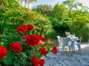 Case FortullinoにあるHoliday Home Nella by Interhomeの赤い花の庭園のテーブルと椅子