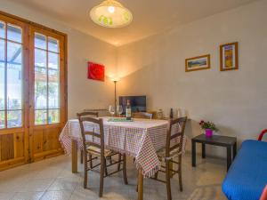 a dining room with a table and chairs and a tv at Apartment Montaleo 2 by Interhome in Casale Marittimo