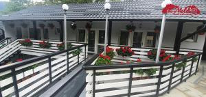 uma casa com caixas de flores na varanda em Cazare Moldi Btt em Câmpulung Moldovenesc