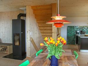 a dining room with a table with a vase of flowers at Chalet Börtji by Interhome in Furna